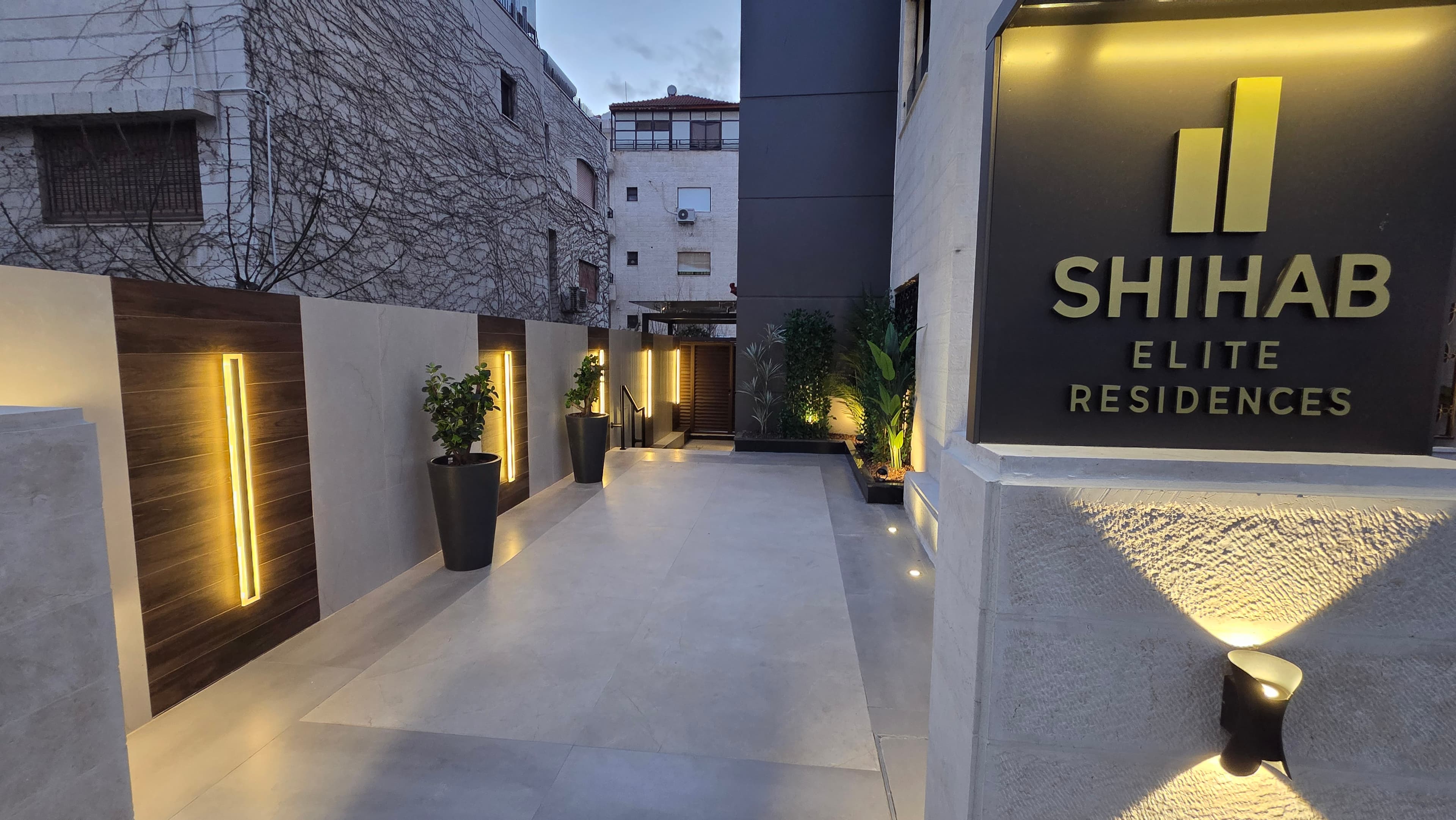 Building entrance walkway with signboard and warm evening lighting